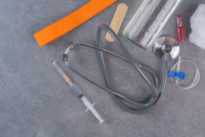 Medical tools including stethoscope, syringe, and bandage arranged on a table, symbolizing Personal Healthcare Access and essential patient care.