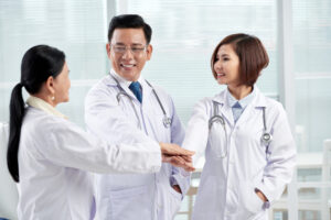 Group of doctors collaborating and showing teamwork, representing Personal Healthcare Access in a modern medical setting.