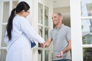 Doctor home visit greeting patient at doorstep for medical care