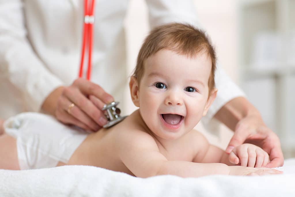 Smiling baby receiving gentle treatment from pediatric doctor, showing Nawadipa’s friendly Child Health Services.