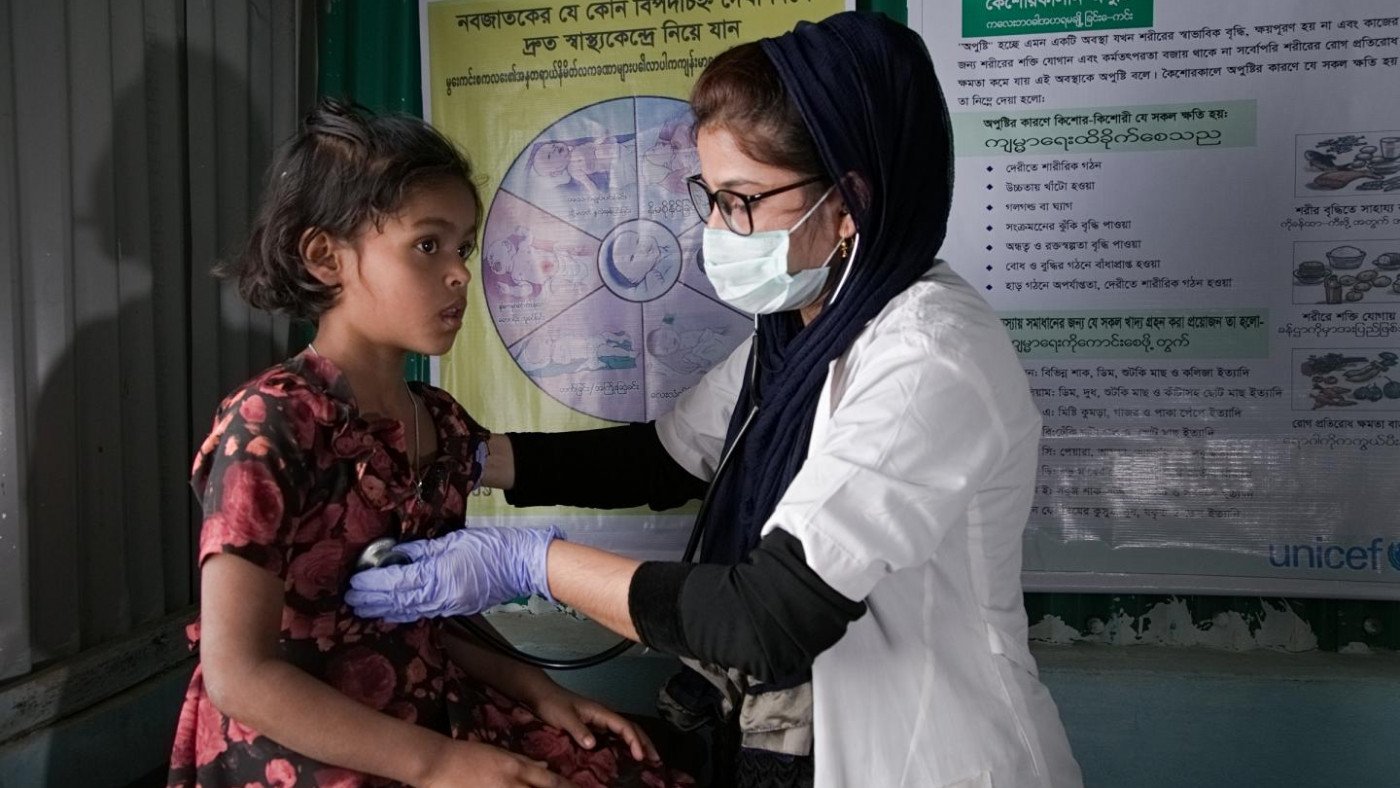 Doctor providing Local Healthcare services to children in Bali community clinic.